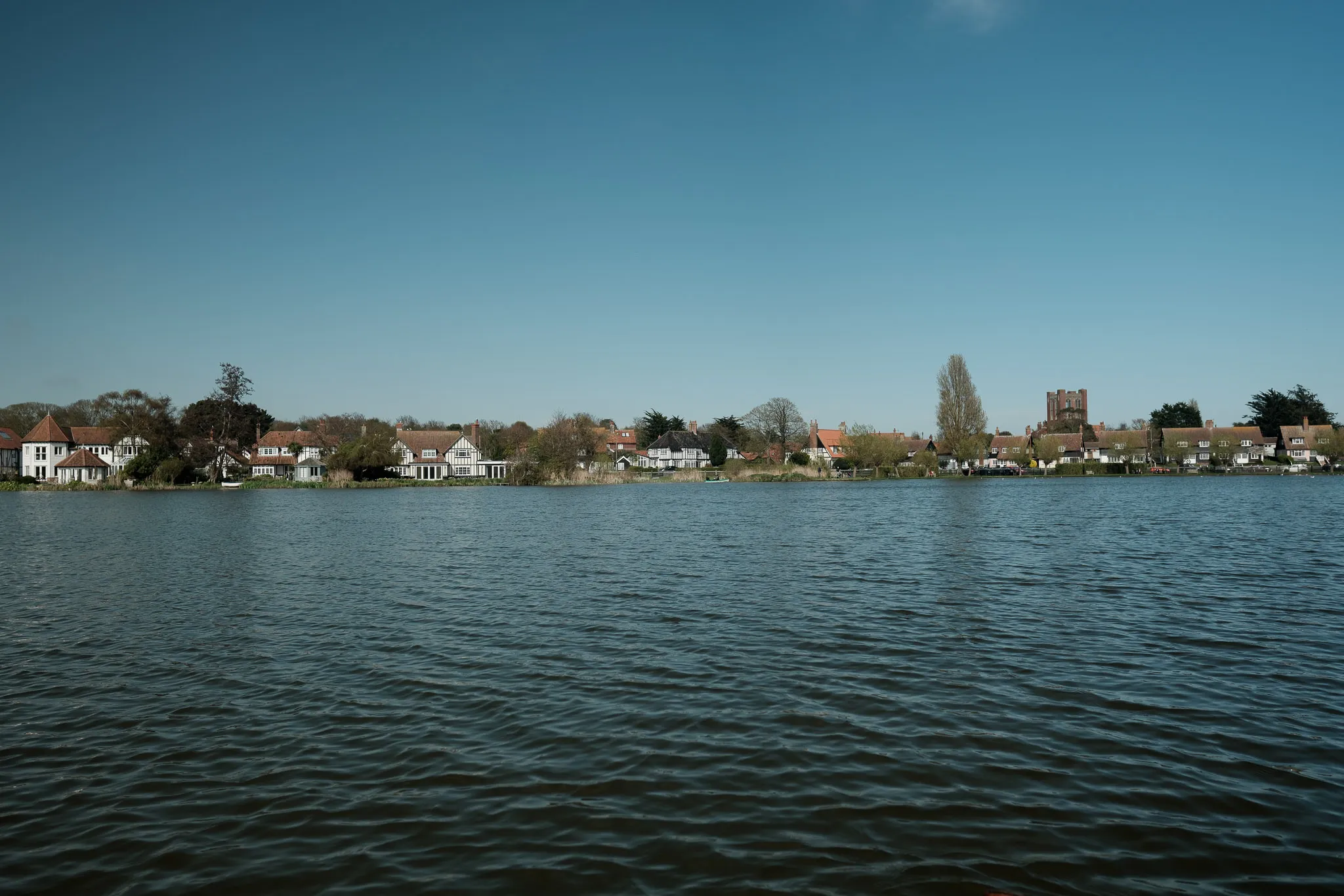 body of water with a small village in the background